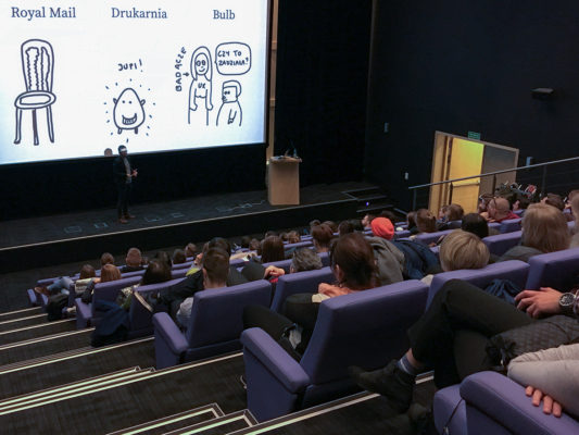 Wojtek Kutyła w sali wykładowej Strefy Startup w Gdyni, opowiadający o service design.