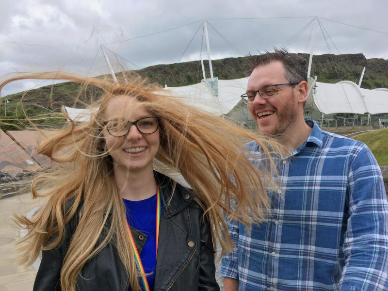 Anya Braun z rozwianymi włosami i Chris Gibbons, roześmiany po uszy. Fotografia z konferencji UX Scotland 2018.